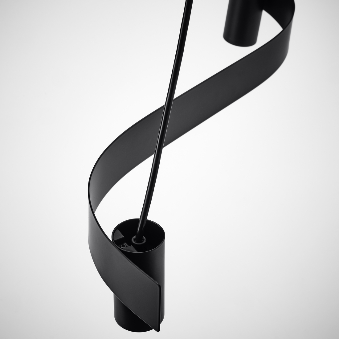 Detailed shot of a modern black metal pendant light featuring a curved S-shaped ribbon design against a light background.