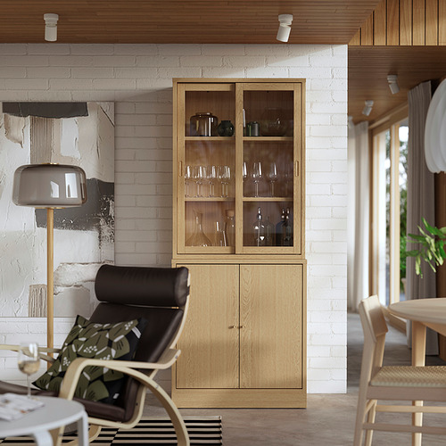 Sala de estar moderna con mueble de roble TONSTAD, expositor de vinos y sillón de cuero. Estilo escandinavo con espacio acogedor y organizado.