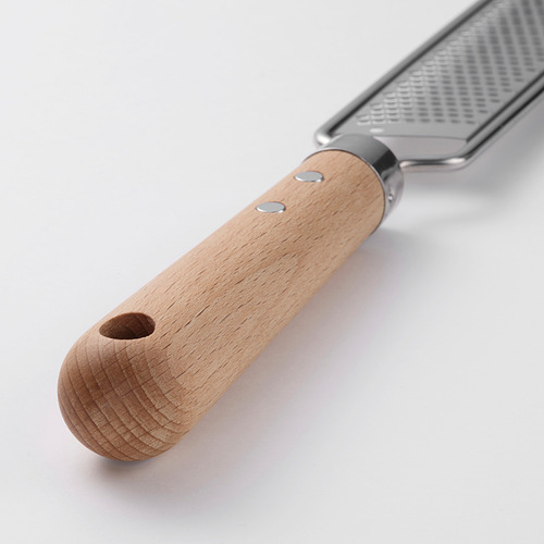 Rallador de acero inoxidable con mango de madera y orificio para colgar. O rallador resistente de acero inoxidable con mango de madera y gancho para colgar.