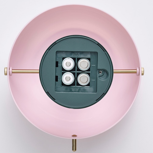 Una lámpara led que funciona con pilas con un puerto de carga usb-c, montada sobre una base circular rosa con varillas doradas ajustables.