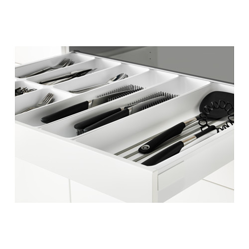 Cajón de cocina organizado que muestra utensilios: cuchillos, tenedores, cucharas y utensilios de cocina en compartimentos.