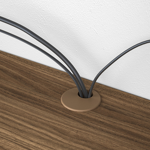 Escritorio de madera con orificio para la gestión de cables, dos cables negros cuidadosamente organizados.