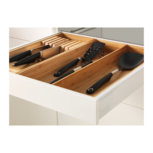 Organizador de cajones de cocina con cuchillos, utensilios e insertos de bambú para un almacenamiento ordenado.