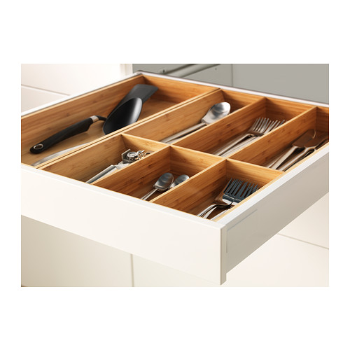 Cajón de cocina organizado con separadores de bambú que sostienen utensilios.