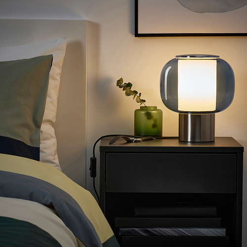 Lámpara azul en la mesita de noche, luz cálida, decoración moderna.