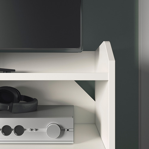 Moderno centro de entretenimiento blanco con televisor de pantalla plana, auriculares y barra de sonido en los estantes.