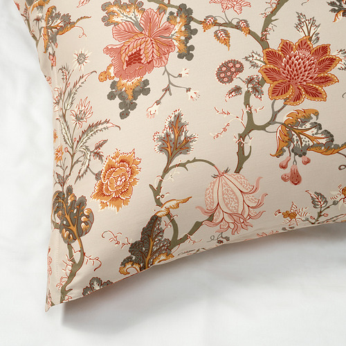 Almohada decorativa con estampado floral sobre fondo beige, tejido suave, artesanía detallada.