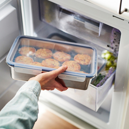 Persona colocando un recipiente transparente con alimentos en el refrigerador, sellado con una tapa a prueba de fugas para mayor frescura.