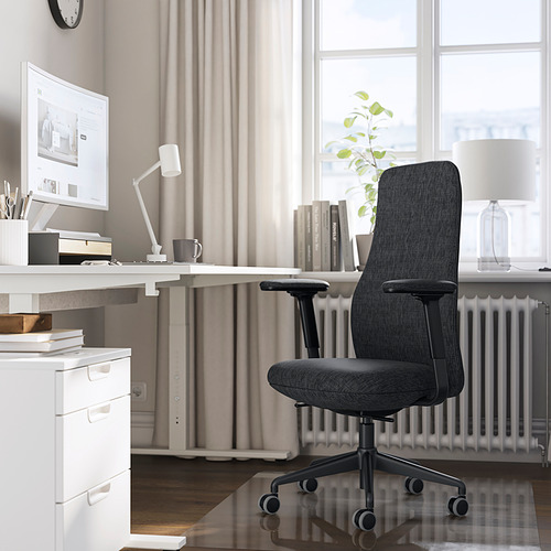Configuración de oficina en casa con silla ergonómica GRÖNFJÄLL gris oscuro, escritorio blanco y computadora. La silla se adapta perfectamente debajo del escritorio, ajustable para mayor comodidad.