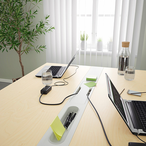 Moderna mesa de conferencias con tomas de corriente integradas y gestión de cables, ideal para reuniones y trabajo colaborativo.