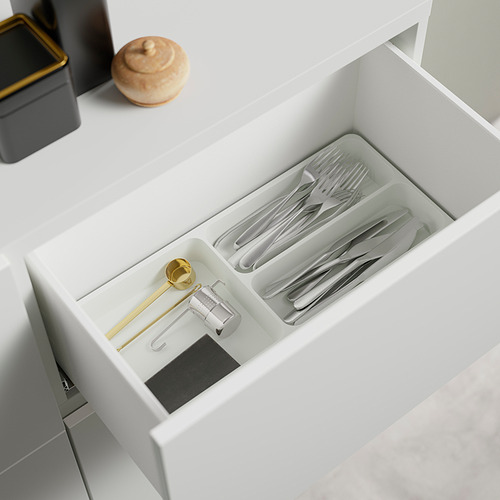 Cajón blanco abierto con organizador de cubiertos y utensilios en su interior. Espacio visible de los mecanismos de empuje y apertura.