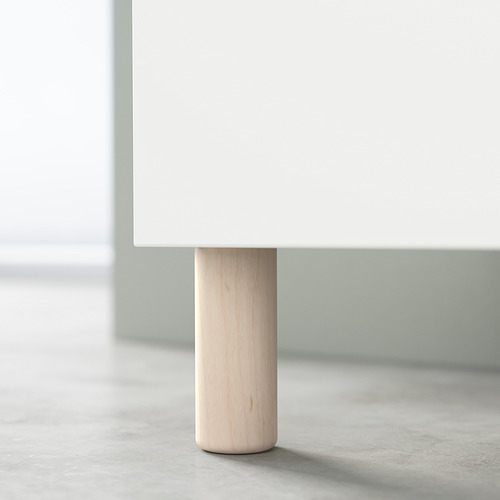 Pata redonda de madera, ligeramente teñida, que soporta la mesa blanca.