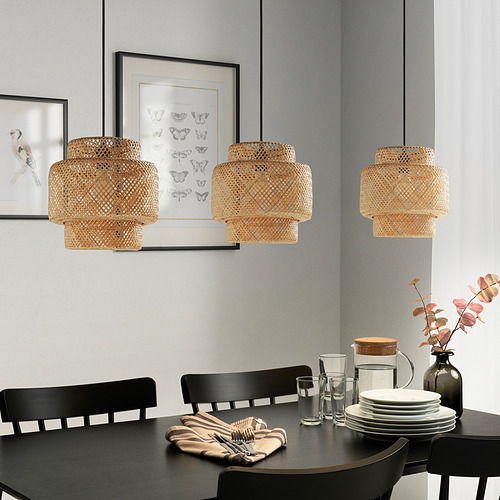 Lámparas de bambú sobre la mesa de comedor con un cálido resplandor y configuración de mesa.