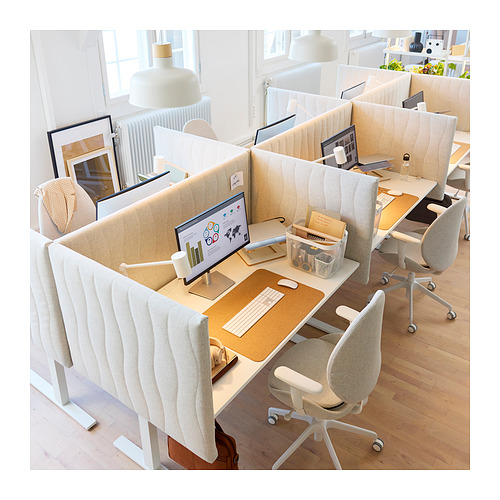Moderno espacio de oficina con escritorios, sillas y particiones de colores claros. Computadoras y accesorios cuidadosamente dispuestos, promoviendo un entorno de trabajo enfocado.