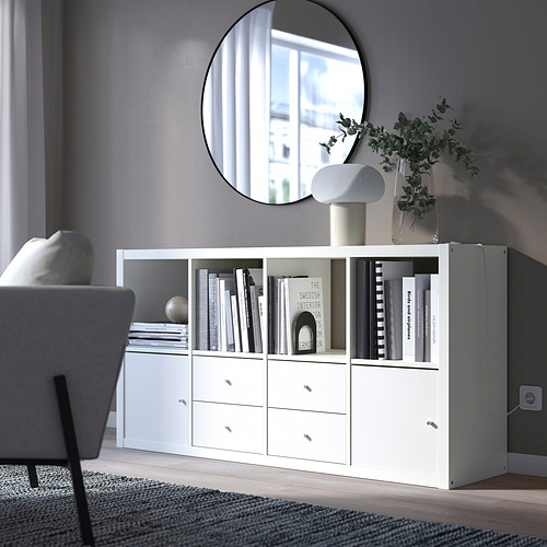 Almacenamiento KALLAX con libros, lámpara y planta, con espejo.