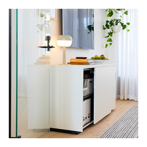 Almacenaje de oficina GALANT blanco con estantes ajustables y cerradura. Lámpara moderna, libros, frutas y plantas.