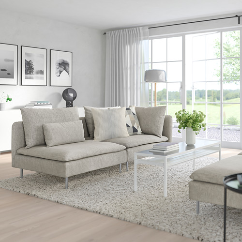 Sala de estar moderna con sofá seccional SÖDERHAMN gris claro, mesa de centro blanca y grandes ventanales.