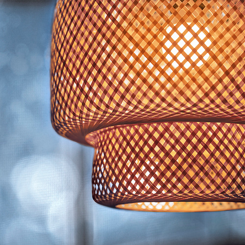 Dos lámparas colgantes de bambú intrincadamente tejidas emiten una luz cálida y acogedora. Su diseño artesanal presenta patrones naturales, emitiendo una iluminación suave y ambiental.