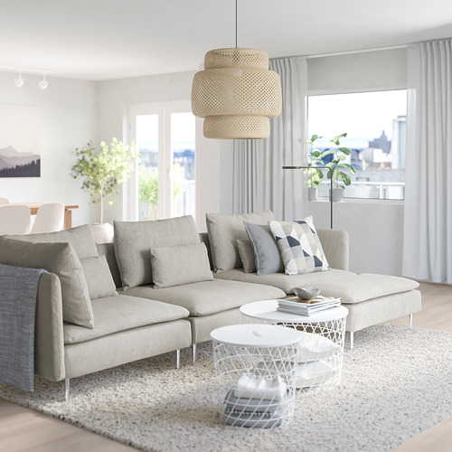 Salón moderno con sofá SÖDERHAMN gris, cojines, mesas, alfombra, plantas, cortinas y grandes ventanales.
