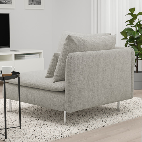 Un moderno sofá SÖDERHAMN gris con mesa auxiliar. El sofá tiene cojines sueltos para mayor comodidad, y la mesa sostiene una taza blanca.