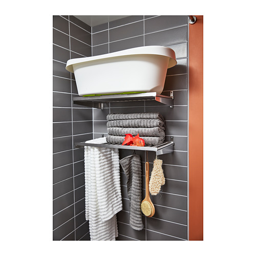Estantería de pared de acero inoxidable con bañera blanca, toallas grises, cepillo rojo, esponja para colgar y estropajo, almacenamiento en el baño moderno.