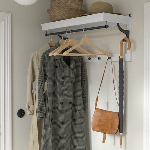Configuración de entrada organizada con percha BUMERANG con chaquetas colgantes, sombrero, canasta, bolso y paraguas.
