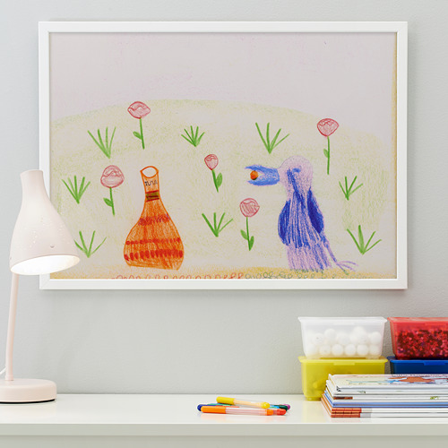 Dibujo infantil enmarcado con lámpara y material de arte.