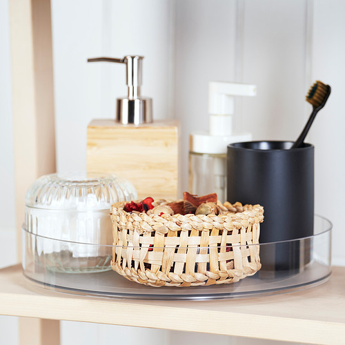 Un organizador de encimera de cocina con dispensador de jabón, soporte para cepillos de dientes y cesta decorativa.