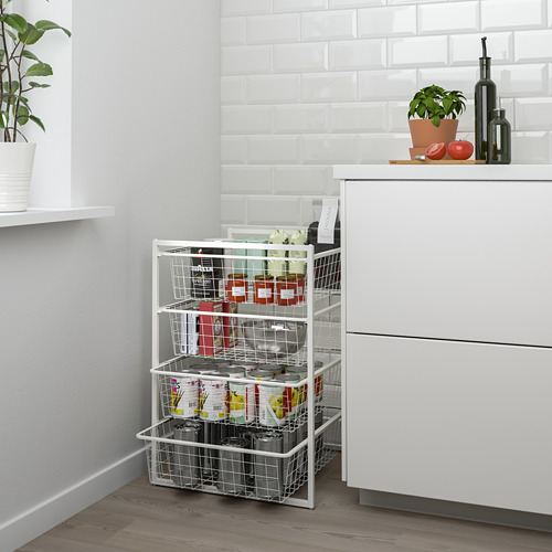 Estante de almacenamiento JONAXEL blanco con múltiples cestas de alambre que contienen varios artículos, colocado junto a un gabinete blanco en una cocina moderna.
