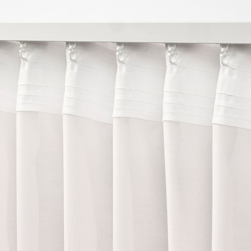 Cortinas blancas transparentes con ganchos que cuelgan uniformemente, difuminando la luz del día.