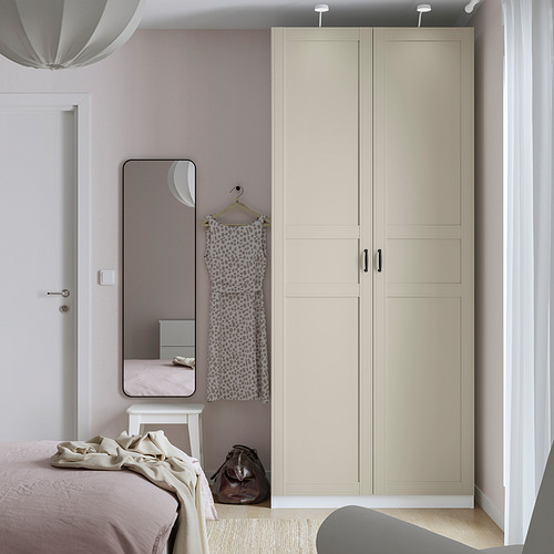 Dormitorio moderno con armario IKEA PAX, espejo y cama rosa-beige.
