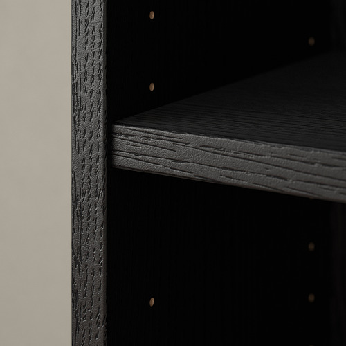 Esquina de estantería de madera negra, bordes elegantes, acabado texturizado, estantes vacíos.