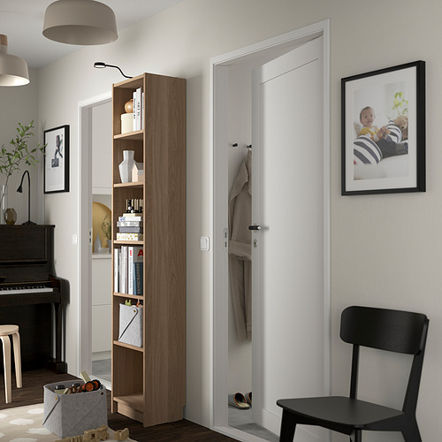 Pasillo moderno con librería Billy, silla negra, ganchos para abrigos y foto de bebé.