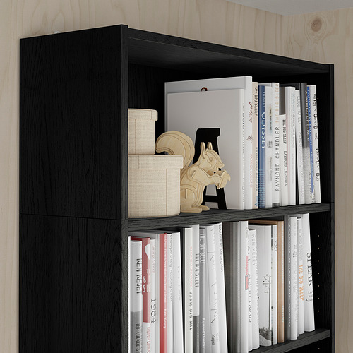 Estantería negra con libros y elementos decorativos, maximiza el almacenamiento vertical, parte de la serie BILLY.