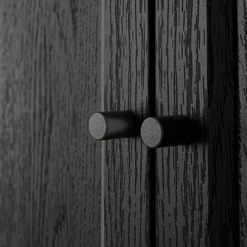 Primer plano de textura de madera negra con dos perillas cilíndricas, que muestra la artesanía de calidad de BILLY.