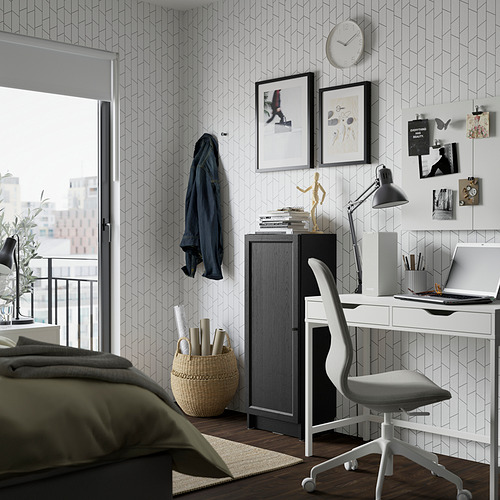 Moderna zona de estudio con librería BILLY y silla giratoria junto a una ventana.