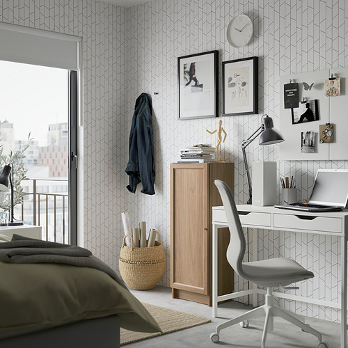 Salón moderno con librería blanca BILLY. Almacenamiento elegante y versátil junto a un escritorio blanco y una silla gris.