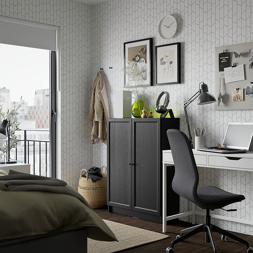 Dormitorio moderno con librería BILLY gris oscuro, cama verde oliva, escritorio y luz natural.