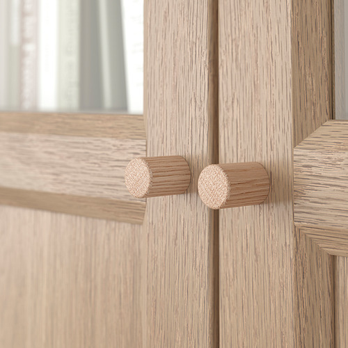 Gabinete de madera ligera con dos pomos circulares, que muestra una textura de grano de alta calidad y una construcción robusta.