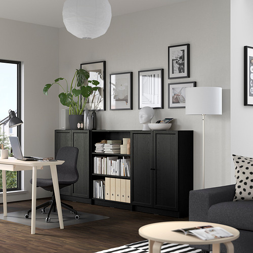 Moderna oficina en casa con estantería Billy, escritorio, planta, arte, sofá y lámpara.