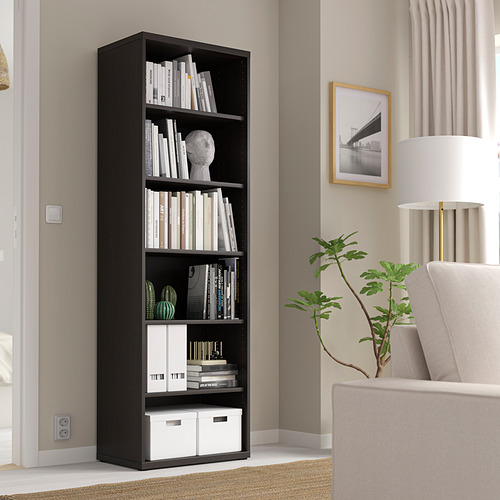Estantería negra BESTÅ con libros y decoración en salón moderno.