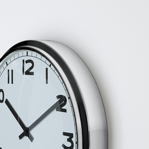 Primer plano de un reloj de pared redondo con manecillas y números negros, esfera blanca y marco plateado. La hora mostrada es 10:10.