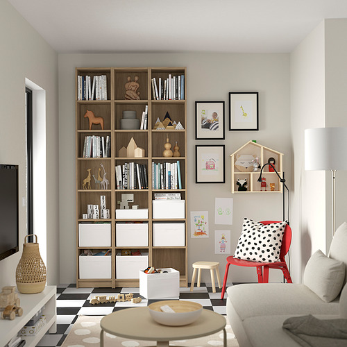 Acogedora habitación para niños con librería BILLY, alfombra a cuadros, silla roja y decoración personal.