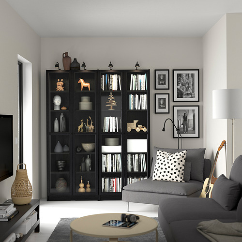 Sala de estar con estantería negra, sofá, mesa de centro, guitarra y fotos.