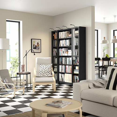 Sala de estar moderna con estantería negra BILLY, muebles blancos, piso a cuadros, gran ventanal y luces colgantes.