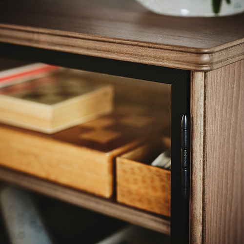 Mueble de TV de madera oscura con cajón abierto, libros en el interior y puerta de cristal. Diseño inteligente y organizado.