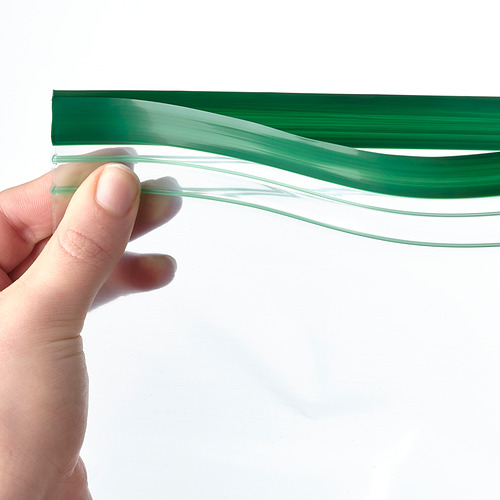 Una mano que sostiene una bolsa de almacenamiento de alimentos verde transparente y reutilizable, lo que demuestra su naturaleza hermética y flexible.