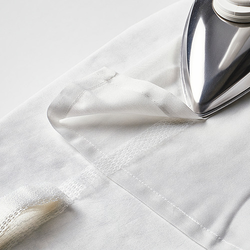 Una plancha de plata presiona una cortina blanca transparente, mostrando su capacidad para suavizar y dar forma a la tela.