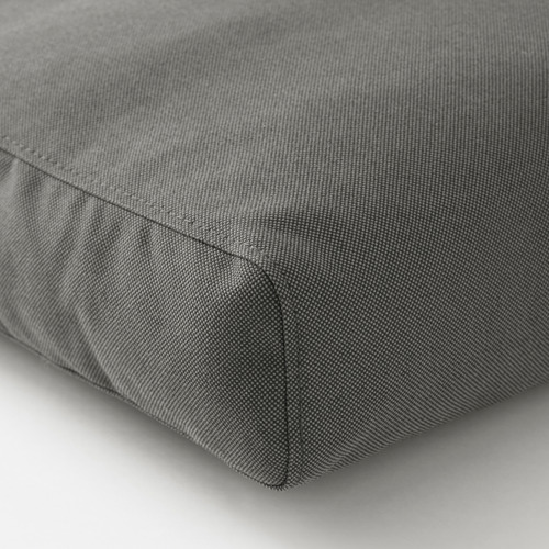 Primer plano de un cojín de exterior gris duradero. La tela texturizada, cuidadosamente cosida, indica alta calidad.