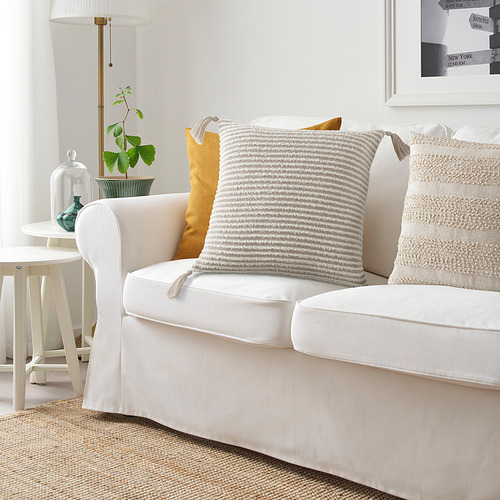 Acogedora sala de estar con sofá blanco, cojín KRYPLJUNG y plantas.